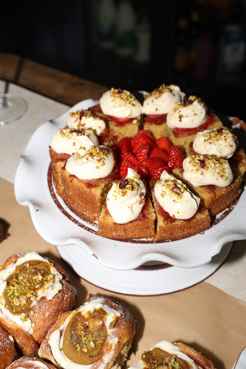 Dessert with cream and berries on a white cake stand