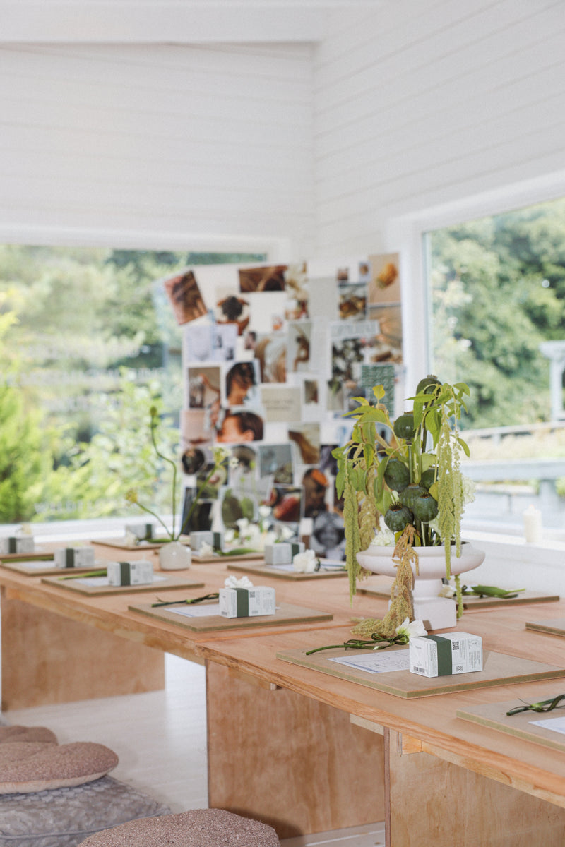 Modern interior with wooden tables, decorative plants, and a wall of photos.
