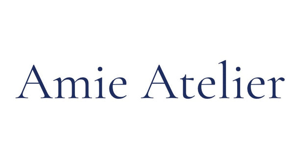 Amie Atelier Logo, Blue writing with white background.